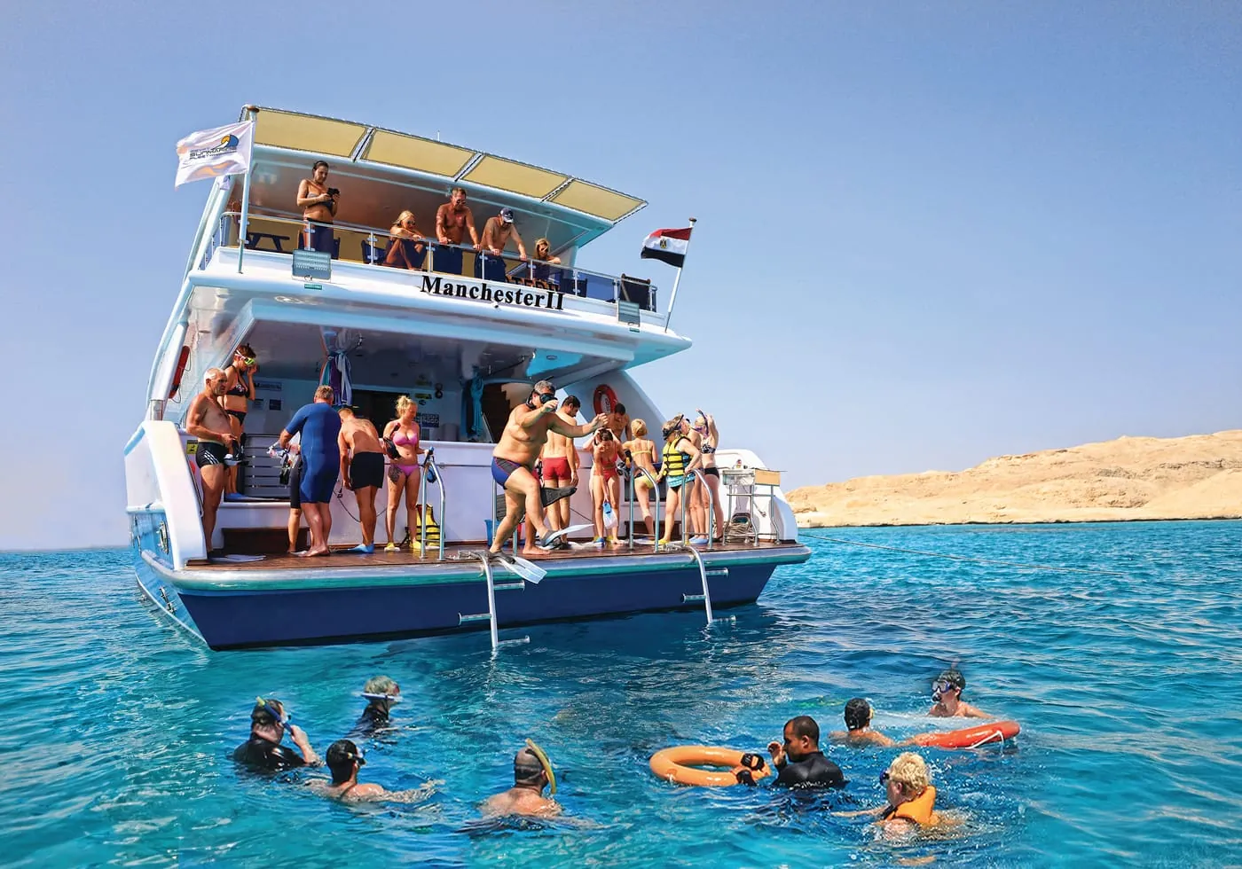 A day boat with swimmers in the water at Ain Sokhna